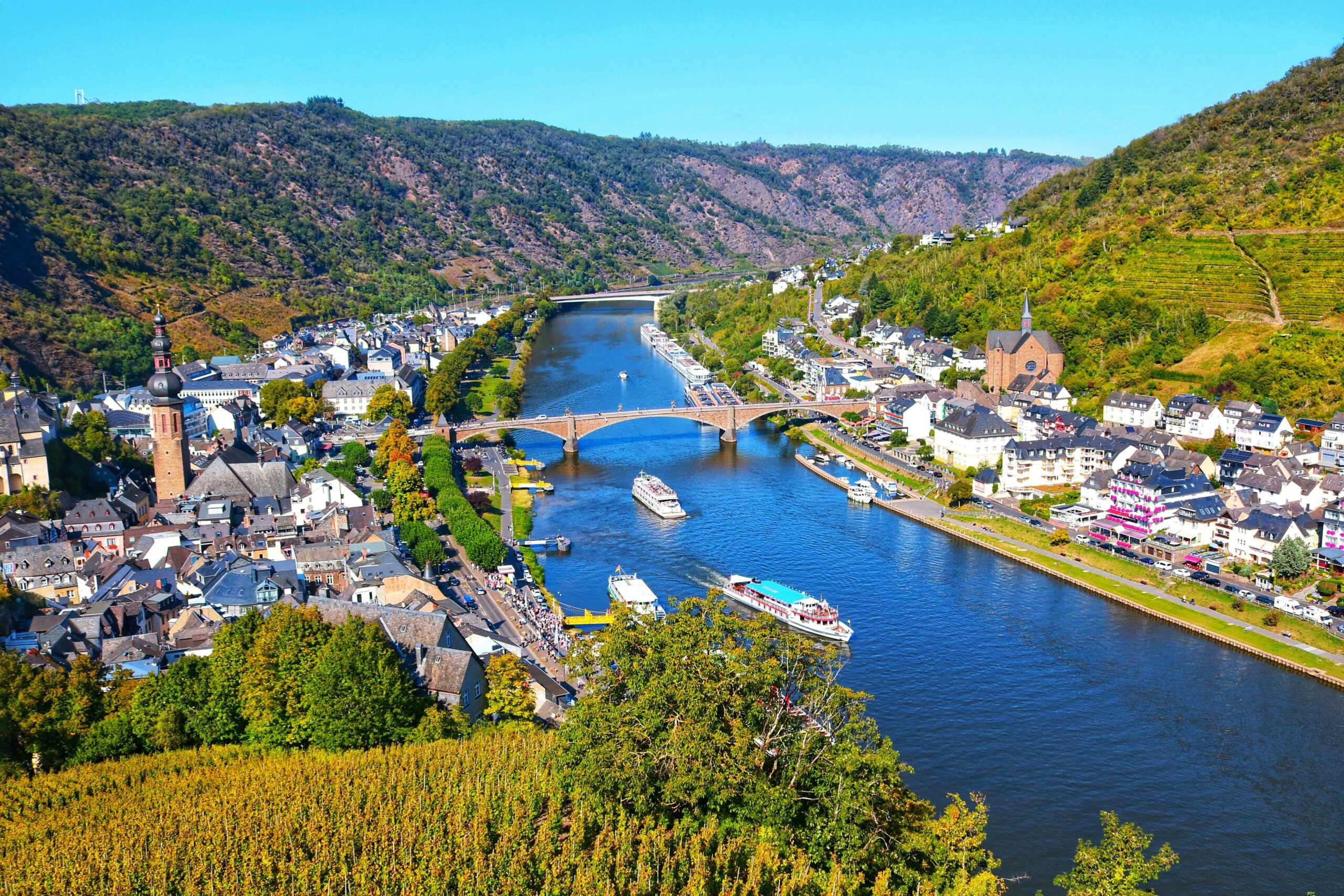 Aerial view of Cochem, Rhineland-Palatinate, Germany with the Moselle River, boats, and lush vineyards.